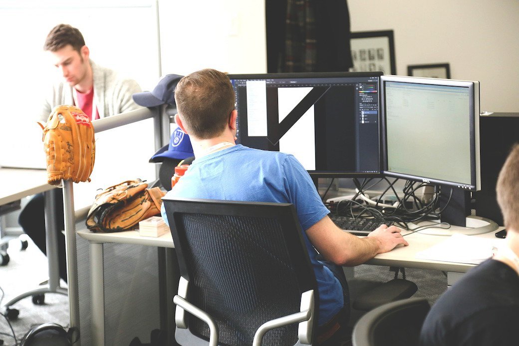 a person sitting in front of two monitors