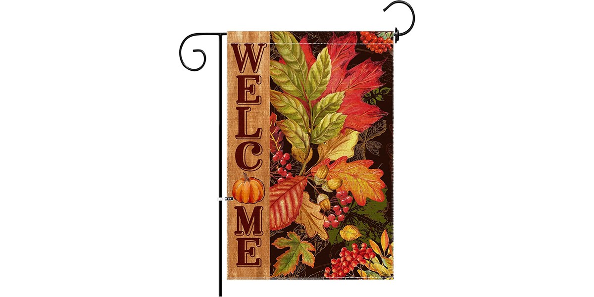A standing flag that has fall leaves and a welcome message on it