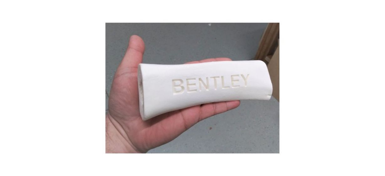 person holding personalized carved bone with a name on it