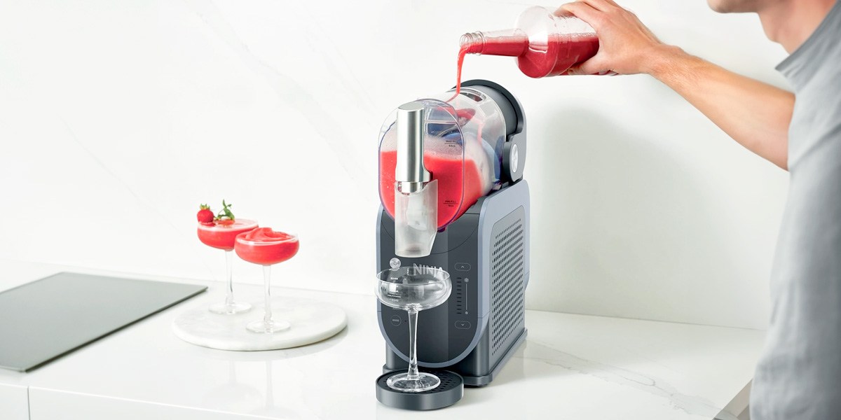 A person pouring a drink mix into a Ninja Creami